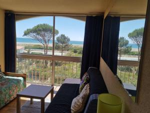 - un salon avec un canapé et une grande fenêtre dans l'établissement Appartement Port Leucate, 2 pièces, 4 personnes - FR-1-81-99, à Port-Leucate