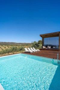 a swimming pool with lounge chairs and a house at Acushla Golden House Douro in Lodões