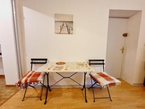 einen Tisch und zwei Stühle in einem Zimmer in der Unterkunft STUDIO CALME 22 m2 CENTRE VILLE NANTUA in Nantua