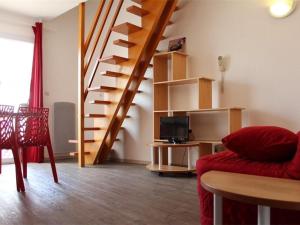 ein Wohnzimmer mit einer Treppe und einer roten Couch in der Unterkunft Appartement La Rochelle, 1 pièce, 4 personnes - FR-1-246-9 in La Rochelle