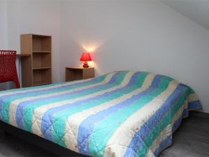 Bett mit farbenfroher Bettdecke in einem Zimmer in der Unterkunft Appartement La Rochelle, 1 pièce, 4 personnes - FR-1-246-9 in La Rochelle