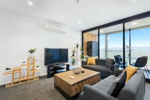 a living room with a couch and a tv at Valley View Apartment with Mountain Views & Wi-Fi in Auckland