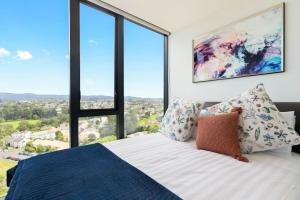 a bedroom with a large bed with large windows at Valley View Apartment with Mountain Views & Wi-Fi in Auckland