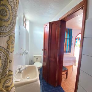 a bathroom with a sink and a toilet at Hostal Chasqui in Otavalo