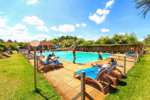 a group of people sitting around a pool at a resort at Poa Place Resort & Hotel - Where Nature Meets Comfort Eldoret in Eldoret