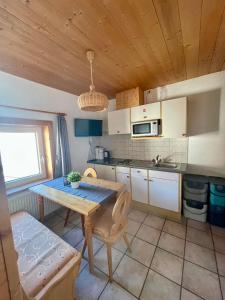 eine Küche mit einem Holztisch und einem Esszimmer in der Unterkunft APART Kirschner in Sankt Leonhard im Pitztal