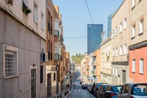 eine Stadtstraße mit Autos, die an den Seiten der Gebäude geparkt sind in der Unterkunft Apartamento Plaza Castilla in Madrid