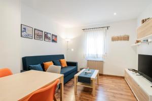 sala de estar con sofá azul y mesa en Apartamento Plaza Castilla en Madrid