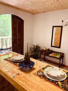 una mesa con platos y vasos encima en Aconchego Penedo, en Penedo