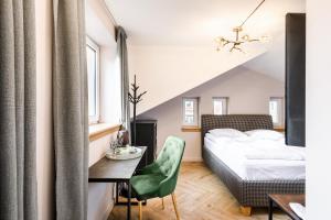 Schlafzimmer mit einem Bett, einem Schreibtisch und einem Stuhl in der Unterkunft Adler Aparthotel in Klaipėda