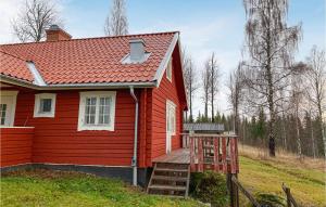 a red house with a porch and a ladder next to it at 5 Bedroom Awesome Home In Kopparberg in Ställdalen