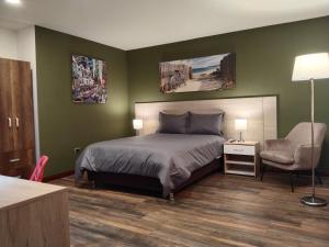 a bedroom with green walls and a bed and a chair at Hotel Boutique Quinta Camacho in Bogotá +120 photos
