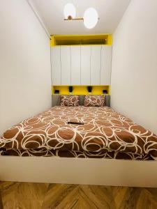 ein Schlafzimmer mit einem Bett mit einer weißen Wand in der Unterkunft Nivas Apartments-Palace of Culture in Iaşi