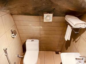 a small bathroom with a toilet and a sink at Foggy Knolls Resort in Vagamon