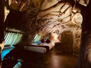 a bedroom in a rock cave with a bed in a room at Foggy Knolls Resort in Vagamon