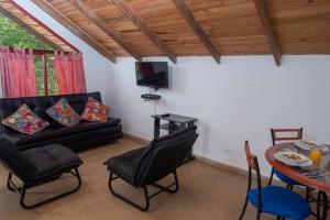a living room with a black couch and a table at Ecovilla Cali in Cali