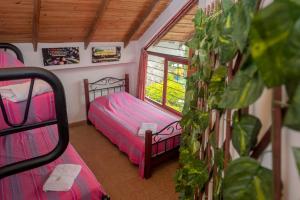 a small room with two beds and a window at Ecovilla Cali in Cali