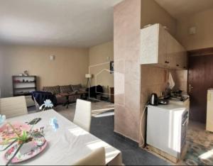 a kitchen and living room with a table and a refrigerator at Apartment Podgorica centre in Podgorica