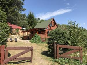 a wooden barn with a fence in front of it at Domek letniskowy nad jeziorem mazury Wilimy 127 in Wilimy