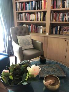 a living room with a chair and a glass table at Casa Sandra Elisa in Maasmechelen