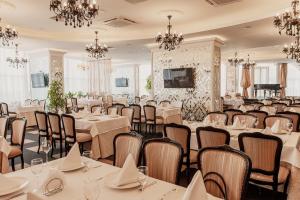 a banquet room with tables and chairs and chandeliers at Olymp Kazan in Kazan