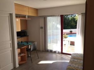 a room with a bed and a kitchen with a sliding glass door at Appartement La Rochelle, 1 pièce, 2 personnes - FR-1-246-304 in La Rochelle