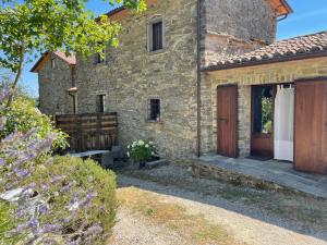 an external view of a stone house with a wooden door at Borgo Il Cantuccio - Casa Grande con piscina condivisa in Molino di Renzetti