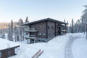 a building in the snow with a road in front of it at Kurula's Resort in Pyhätunturi