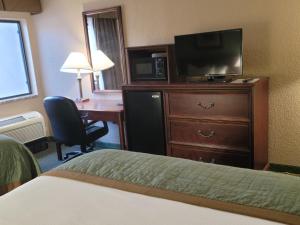 um quarto de hotel com uma cama, uma televisão e uma secretária em Bay Mountain Inn Cherokee Smoky Mountains em Cherokee