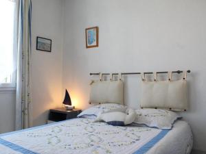 een slaapkamer met een bed met 2 kussens bij Maison Le Grand-Village-Plage, 3 pièces, 4 personnes - FR-1-246A-314 in Grand-Village-Plage