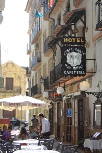 un grupo de personas sentadas en mesas fuera de un hotel en Hotel Hermanos Macias, en Ronda