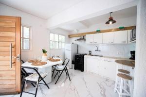 biała kuchnia z białym stołem i krzesłami w obiekcie Casa duplex 2 dormitorios by depptö w mieście Punta del Este