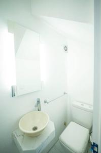 a white bathroom with a sink and a toilet at Casa duplex 2 dormitorios by depptö in Punta del Este