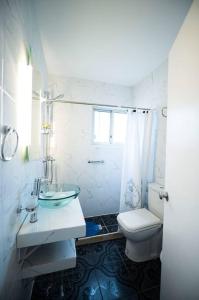 a white bathroom with a sink and a toilet at Casa duplex 2 dormitorios by depptö in Punta del Este
