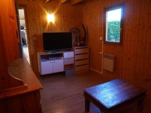 ein Wohnzimmer mit einem TV und einer Holzwand in der Unterkunft Chalet Cabourg, 4 pièces, 8 personnes - FR-1-465-22 in Cabourg