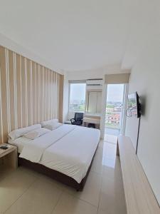 a bedroom with a large white bed and a window at Paradise Room By Vivo Apartment in Seturan