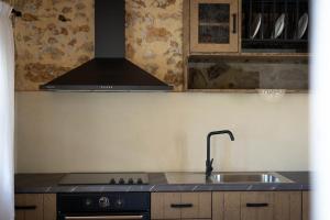 una cucina con lavandino e piano cottura forno superiore di Artemis Traditional House a Valeriános
