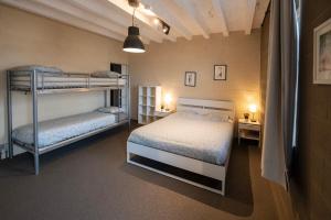 a bedroom with two bunk beds in a room at DE SMISHOEVE met speelruimte, dieren en wellness in Heers