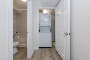 a white bathroom with a washer and dryer in it at *Modern & Cozy* Basement 1 Bdrm W/Fast Internet & Smart TV in Barrie