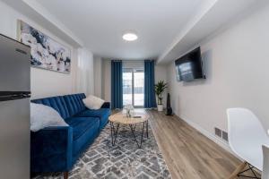 ein Wohnzimmer mit einem blauen Sofa und einem Tisch in der Unterkunft *Modern & Cozy* Basement 1 Bdrm W/Fast Internet & Smart TV in Barrie