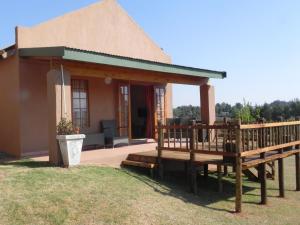 a small house with a porch and a deck at J&B Lodge in Underberg