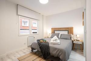 a bedroom with a large bed with two towels on it at Piso en el corazón de Gijón in Gijón