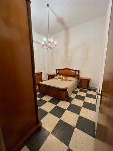 um quarto com uma cama e um piso em xadrez em Casa Mia Russotto 3 Sicilia em Niscemi