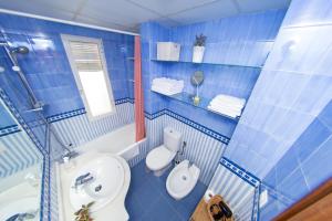 uma casa de banho em azulejos azuis com um WC e um lavatório em MI RETIRO SEVILLANO em Sevilha