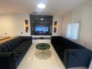 uma sala de estar com um sofá e uma televisão em Vila kasa vali em Zekharya