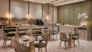 a restaurant with tables and chairs and a kitchen at NH Collection León Plaza Mayor in León