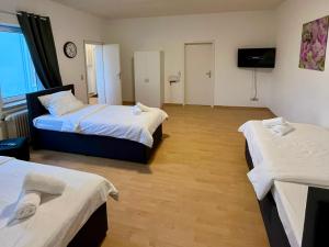 Habitación de hotel con 2 camas y TV en Central Apartments - Work&Stay, en Neumünster