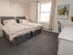 1 dormitorio con 2 camas y ventana en Ty Canol, en Rhyl
