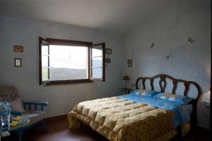 a bedroom with a bed and a window and a chair at Agriturismo La Leggenda in Santa Fiora