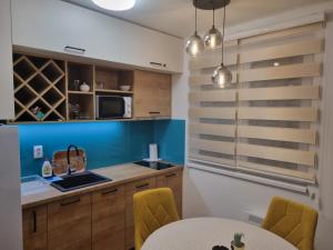 a kitchen with wooden cabinets and a table with yellow chairs at Vila Jahor Apartman Miro in Jahorina